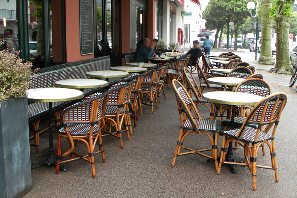 Bar basque et sa jolie terrasse de rue au mobilier en rotin naturel Terrasse de bar au coeur de St Jean De Luz